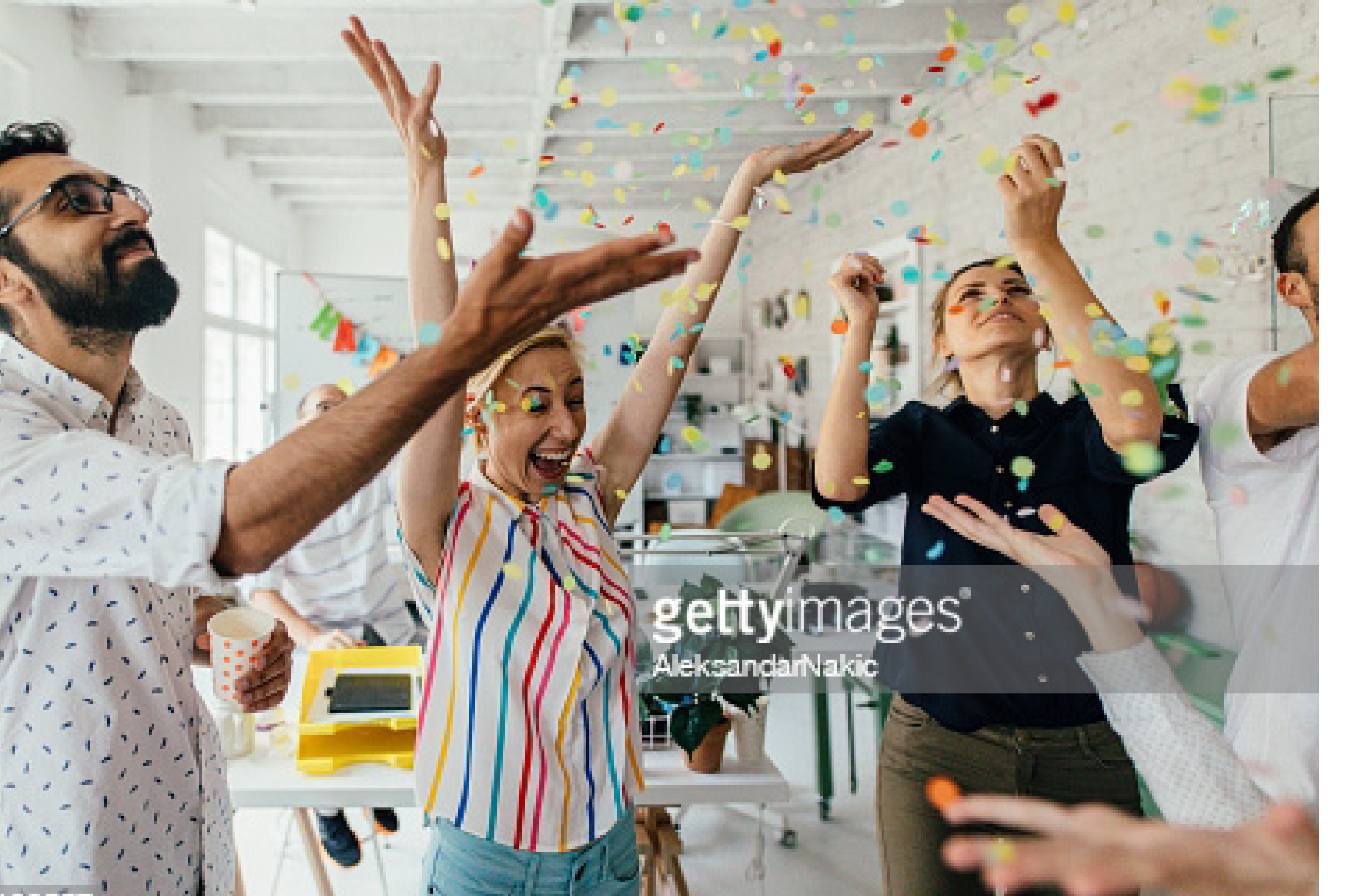Photo of a group of coworkers having a happy occasion and celebrating together in their office